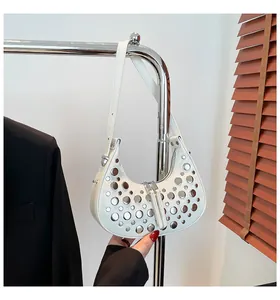 Gros plan sur un sac croissant blanc en cuir avec rivets argentés et double zip