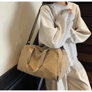Détail du sac de voyage kaki montrant le tissu en nylon et la bandoulière réglable