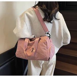 Vue détaillée du sac de voyage en nylon rose avec compartiment chaussures sur escalier