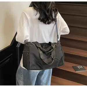 Détail du sac de voyage noir imperméable avec poignées et bandoulière réglable