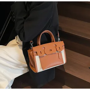 Detail of contrast stitching and leather-canvas texture on a stylish crossbody bag