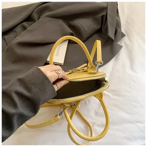 Chic yellow shell-shaped handbag with adjustable strap in pebbled vegan leather
