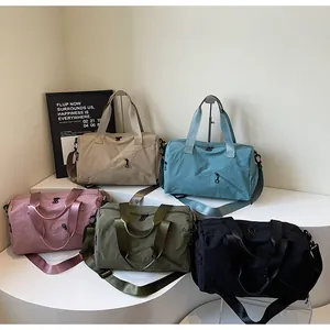 Collection de sacs de fitness en nylon en cinq couleurs sur un socle blanc