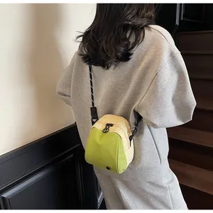 Detail view of green and beige nylon crossbody bag with adjustable wide logo shoulder strap