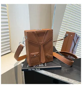Dettaglio della borsa a tracolla marrone con design creativo a forma di giacca e cravatta