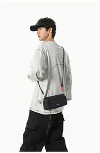 Detailed view of black nylon crossbody bag with white logo and woven shoulder strap