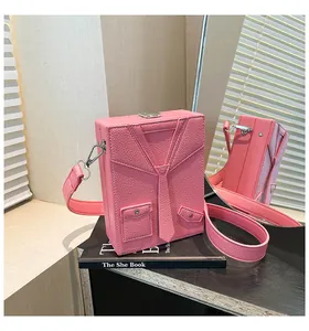 Borsa a scatola rosa con design a cravatta e pelle martellata su una superficie a specchio