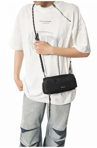 Crossbody sport bag in black nylon fabric with woven drawstring detail on model