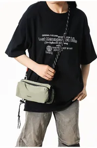 Detail of green nylon crossbody bag with textured fabric and paracord shoulder strap
