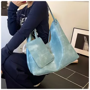Dettaglio della borsa tote azzurra vintage con finitura ruvida e pochette abbinata