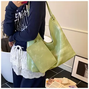 Dettaglio della borsa tote grande verde erba con trama marmorizzata e mini pochette