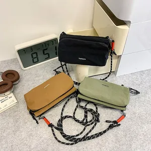 Three minimalist outdoor crossbody bags in black, yellow, and green with braided straps