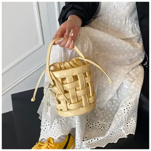 Dettaglio borsa a secchiello intrecciata gialla con fiocco di pizzo perle e coulisse