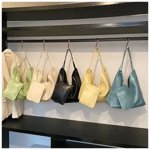 Dettaglio di borse hobo in cinque colori con pochette coordinate su un espositore nero