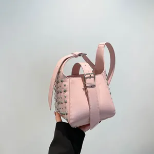 Sac seau rose à rivets argentés avec bandoulière réglable au style streetwear tendance