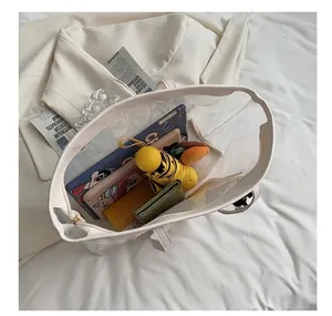 Bovenaanzicht van het ruime interieur van een transparante PVC shopper met leer