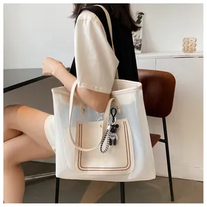 Large transparent PVC tote bag with white leather trim and a cute black bear keychain