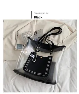 Detail van een transparante PVC tote tas met zwarte bies en een schattige beer hanger