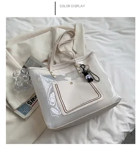 Detail van transparante PVC shopper in beige met beertjeshanger en schaakbordbedel