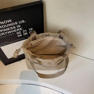 Large capacity beige waterproof nylon tote bag with drawstring closure and wide straps