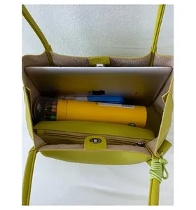 Detail view of large green leather tote bag with magnetic closure and inner compartment
