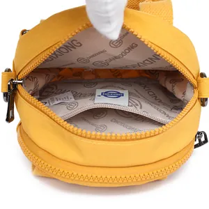 Wasserdichte gelbe Nylon-Umhängetasche mit Logo-Innenfutter und Hauptfach-Detail