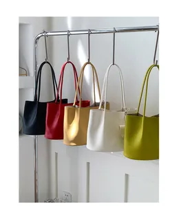 Litchi pattern leather tote bags in five colors hanging on a minimalist metal rack