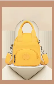 Detailansicht der wasserabweisenden gelben Nylontasche mit Griffen und Logo
