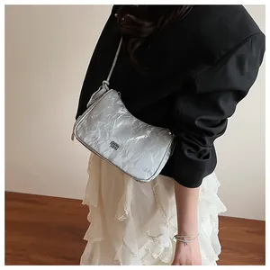 Detail of silver pleated hobo bag with metallic texture and sleek shoulder strap