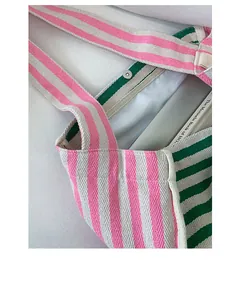 Top-down view of canvas tote bag showing magnetic buckle closure and striped interior lining