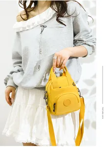 Detail einer leuchtend gelben wasserfesten Nylon-Handtasche mit verstellbarem Schultergurt
