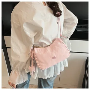 Close-up of pink pleated dumpling bag featuring a cute 3D plush bear charm detail