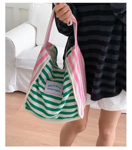 Detail of multi-color striped canvas tote bag with pink CHERISH patch on the front