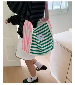 Detail of colorful striped canvas tote bag showing the texture and fabric brand tag