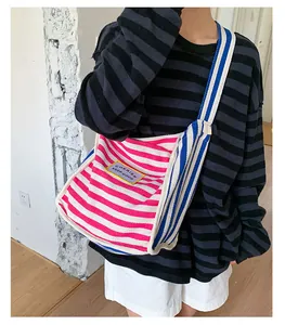 Detail of colorful striped canvas tote bag with yellow label and side contrast stitching