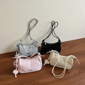 Pleated dumpling bag in silver, black, pink, and white with elephant charm and knot strap