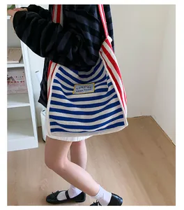 Detail view of large canvas tote bag with bold blue and red contrast stripes