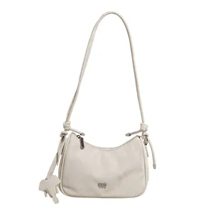 Minimalist beige pleated hobo bag with elephant charm and knotted shoulder strap