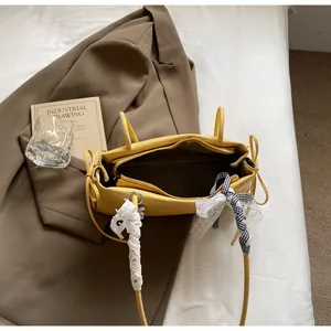 Draufsicht der gelben Achseltasche mit Spitzendetails und Reißverschluss-Innentasche