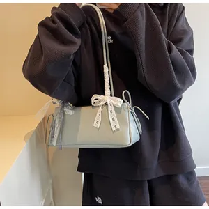 Detailansicht der hellgrünen Schultertasche mit Spitzenbogen und kariertem Schleifenband