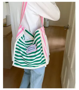 Close-up of green striped canvas tote with pink strap and Cherish Keep Good patch