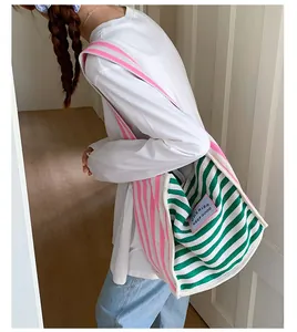 Detail view of pink and green striped canvas tote bag with side shoulder strap