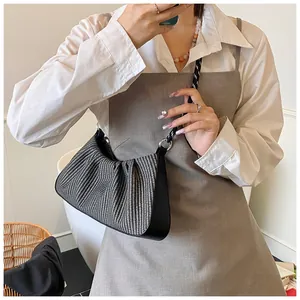 Close-up of black and white woven pleated cloud bag with elegant leather strap detail