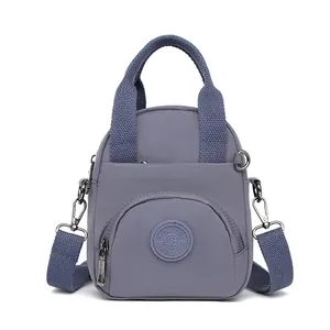 Grauviolette Nylon-Handtasche mit verstellbaren Trägern und Reißverschlusstasche vorne
