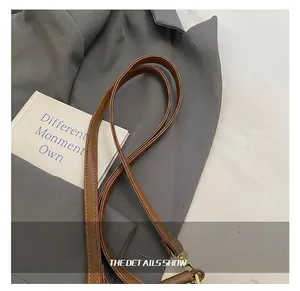 Detail van de verstelbare bruine lederen riem met gouden gesp voor de reisrugzak