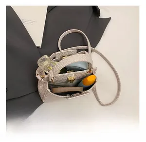 Détails de la capacité interne et boucle dorée du sac beige minimaliste motif crocodile