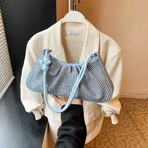 Blue and white woven cloud bag with ruched texture and a braided rope shoulder strap