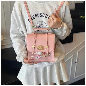 Détail d'un mini sac à dos rose avec fenêtre transparente et broderie de chien mignonne