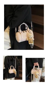 Macro detail of light pink quilted boston bag with cute bear charm and adjustable strap