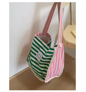 Detail of high-density canvas tote with green and pink stripes and embroidered label